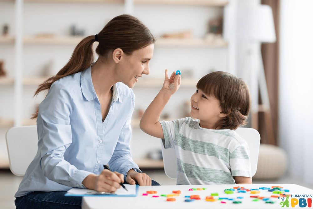 A therapist conducting a play-based assessment session with a child, emphasizing the techniques taught in the Assessment in Play-Based Intervention course.