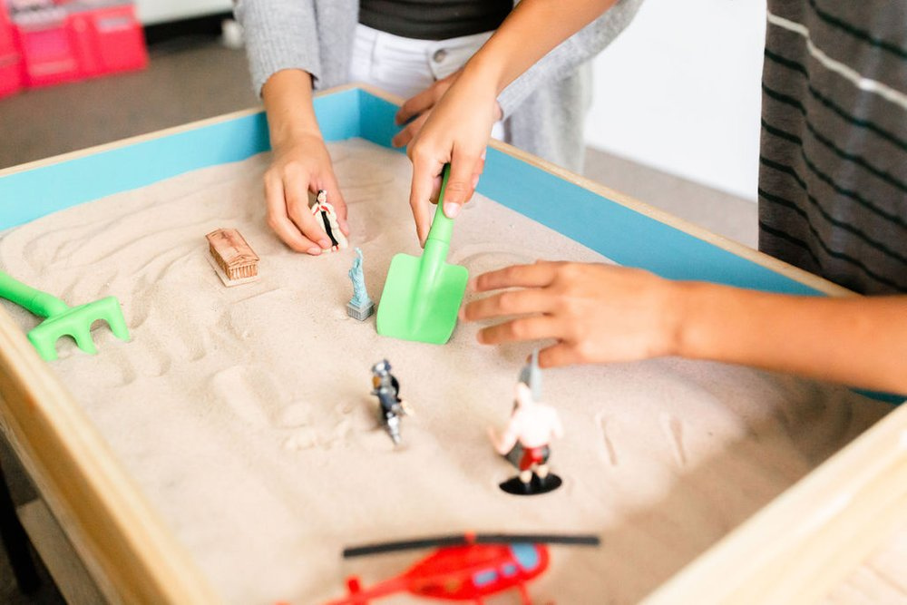 A therapist guiding a sand tray session during the Applying Sand Tray in Practice course, showcasing creative therapy techniques.
