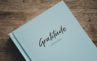 A person writing in a gratitude journal, symbolizing the integration of gratitude practices in wellness counselling.