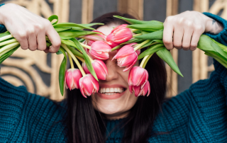 An individual joyfully embracing themselves, symbolizing the practice of self-celebration and self-love.