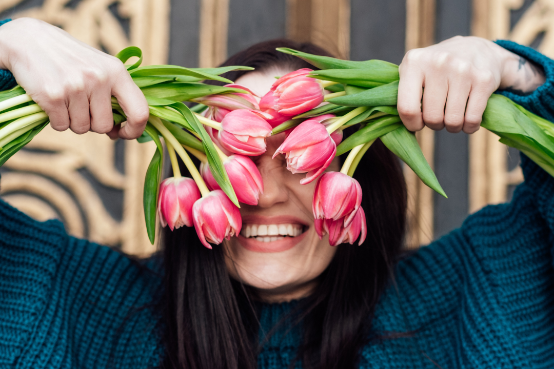 An individual joyfully embracing themselves, symbolizing the practice of self-celebration and self-love.