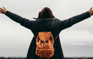 An individual standing confidently with open arms, symbolizing personal empowerment and freedom.