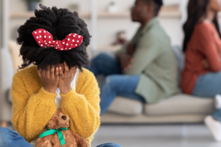 An adult reflecting on past childhood experiences, symbolizing the long-term impact of early trauma on mental health.